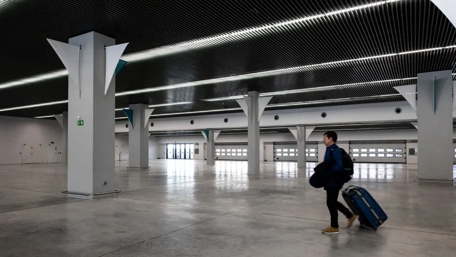 Traveler walking through a modern airport terminal hall